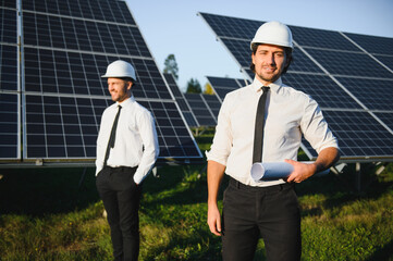 The solar farm, solar panel with two engineers walk to check the operation of the system, Alternative energy to conserve the world's energy, Photovoltaic module idea for clean energy production