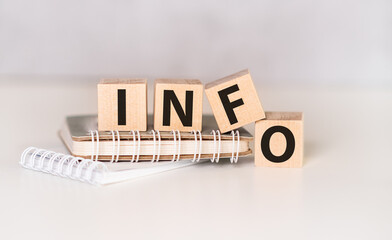 Aufkleber - four wooden blocks with the letters info on the bright surface of a gray table, business concept