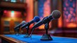© Iurii - Three microphones positioned on a table in a brightly lit indoor conference hall