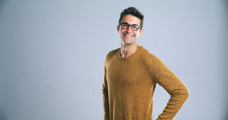 Poster - Glasses, happy and man in portrait for studio, positive attitude and ambitious by backdrop. Gray background, male person and teacher with knowledge for career, spectacle and vision by mockup space