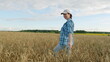 © artifex.orlova - Organic Farm. Agricultural Farm Fields In Sunrise. Work On Agricultural Farm Fields. Farmer Woman Walking Through A Field Of golden Wheat. Moves slowly.