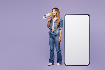 Full body young woman she wear denim jacket violet top casual clothes big huge blank screen mobile cell phone smartphone with area scream in megaphone isolated on plain pastel light purple background.