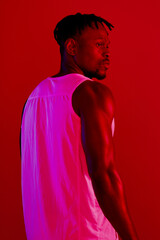 Poster - Back, sports and black man with fitness, neon and training on red studio background. African person, model and athlete with workout, glow and confidence with wellness, healthy player and muscular