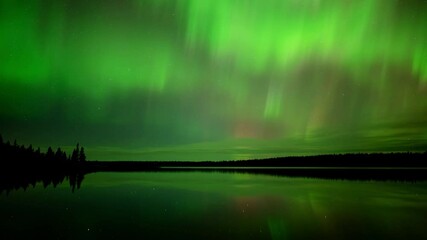 Wall Mural - time lapse of bright green to red aurora moving above and reflecting in a calm lake