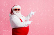 © deagreez - Profile side photo of funny fat overweight santa claus point index finger copyspace x-mas adverts wear overalls suspenders headwear sunglass isolated over pastel color background