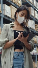 Wall Mural - Vertical Screen : Young Asia businesswoman manager looking for goods using digital tablet check inventory levels stand in retail shopping center. Distribution, Logistics, Packages ready for shipment.