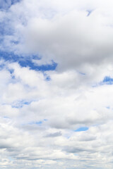 Wall Mural - Many beautiful white fluffy cumulus light clouds in sunlight against blue cloudy sky background texture