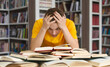 © Prostock-studio - Tired caucasian guy holding head and reading book, getting ready for exams