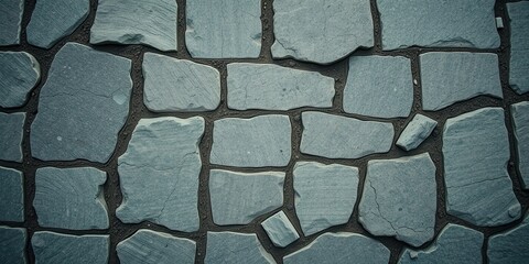 Wall Mural - A close-up view of a stone wall with irregular shaped stones set in dark grey mortar.