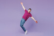 © ViDi Studio - Full body young man wear violet t-shirt casual clothes standing on toes dancing lean back have fun spreading hands isolated on plain pastel light purple background studio portrait. Lifestyle concept.