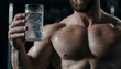 © JP STUDIO LAB - Muscular man holding a glass of water, gym background, symbolizing hydration, fitness, and muscle recovery in an active lifestyle