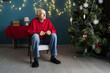 © Andrii Lysenko - lonely pensioner sitting on a chair in the living room at Christmas expecting children