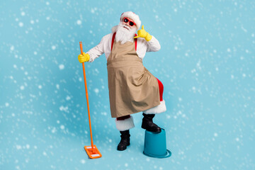 Wall Mural - Full length body size view of nice cheerful Santa cleansing floor doing domestic housework duty showing call me phone sign order isolated bright vivid shine vibrant blue color background