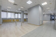 © alhim - A bright working floor with a long corridor in a modern office center. Panoramic window .with blinds, beige laminate. The room is ready to install furniture and equipment.