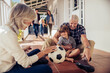 © Marko Geber - Grandparents and grandson playing with soccer ball on house porch