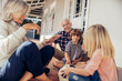 © Marko Geber - Grandparents and grandchildren playing with soccer ball on house porch