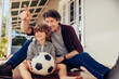 © Marko Geber - Father and son playing with soccer ball on house porch