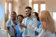 © SnapVault - A cheerful group of doctors and nurses applaud and smile in a hospital, celebrating a success. Their expressions show positivity,unity and dedication, a spirit of solidarity in matters of medical care