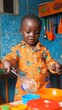 © Sasa Visual - A young boy joyfully plays chef, using a whisk with bright toy utensils around him