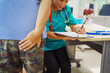 © NanSan - A female doctor sits  a hospital desk,examining a sick male patient with hemorrhoid symptoms,discussing vein swelling at the anus, blood-stained stool,treatment for internal and external hemorrhoids