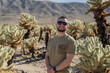 © Julija - man visiting Joshua Tree National park, enjoy Cholla cactus garden.