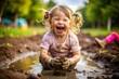 © Евгений Порохин - A young girl is sitting in the mud, covered in dirt and laughing