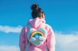 © Running opossum - kidult girl wearing a pink hoodie and a rainbow heart-shaped backpack, enjoying a sunny day with blue sky and clouds