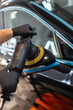 © alones - Professional man holding polishing tool and polishing car after painting. Varnish care and scratch removal. Detailing