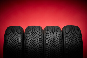 Car tires, winter wheels isolated on red background