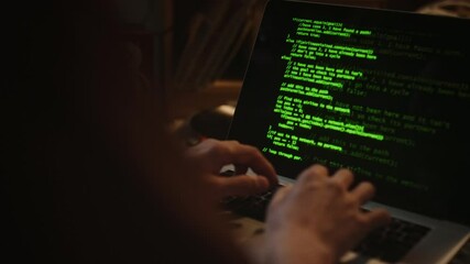 Close-up view of hands of unknown male developer writing code for application using laptop at home