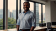 © El So - Portrait of a middle-aged African American male entrepreneur in a light blue shirt, smiling while standing at a desk in a contemporary office with large windows.
