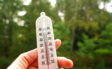 thermometer for measuring outdoor air temperature. tropical rain. meteorological device for observin