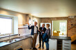 © Marko Geber - Elderly couple consulting with real estate agent in new home kitchen