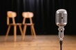 © Anna - Vintage microphone on stage with two chairs in blurred background for podcast or interview