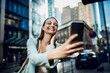 © Geber86 - Young woman using a smart phone on a city street in downtown