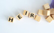 © Pawel - A pile of wooden blocks with the letters HEIR and a purple object in the background