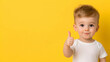 © Ajmeer - a toddler giving a thumbs up on yellow background
