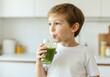 © Anna - Child enjoying a healthy green smoothie in a bright kitchen setting