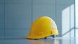© Bijac - yellow safety construction helmet placed on a table, bright and eye-catching against a minimalist backdrop, symbolizing construction and workplace safety