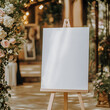 © Prasanth - A blank white welcome sign mockup, size is 24 by 36 inches in portrait orientation, on an easel during a wedding party.