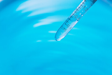 Wall Mural - blue science experiment background,dripping liquid from pipette into test tube in laboratory, closeu