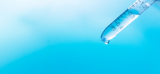 Wall Mural - blue science experiment background,dripping liquid from pipette into test tube in laboratory, closeu
