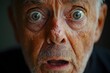 © Milaballe - Elderly man expressing shock with wide eyes in close-up portrait