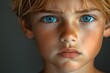 © Milaballe - Close-up portrait of a young child with intense blue eyes and freckles