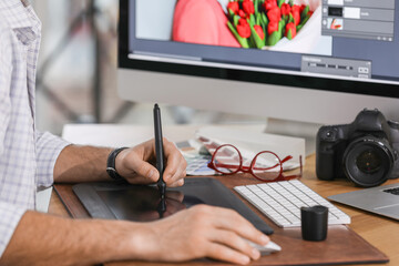 Fototapete - Professional retoucher working on graphic tablet at table, closeup