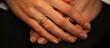 © Fana Art - Close up of a woman's hand with three gold rings on her ring finger.