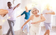 © JackF - Group of multinational sports aged people rehearsing classical dance in dance hall