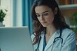 © Mikhail Vorobev - Dedicated female physician in white coat using laptop in her medical office with stethoscope