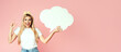 © Prostock-studio - Amazing Offer. Overjoyed blonde girl holding empty speech bubble, pointing finger up, pink studio wall, copyspace