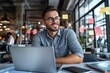 © menon - Professional Man Smiling While Working on Laptop in Modern Office